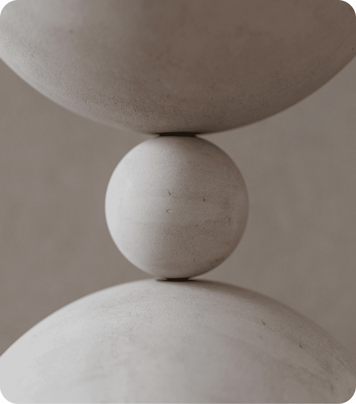 A image of a concrete sphere, balanced between two other larger spheres